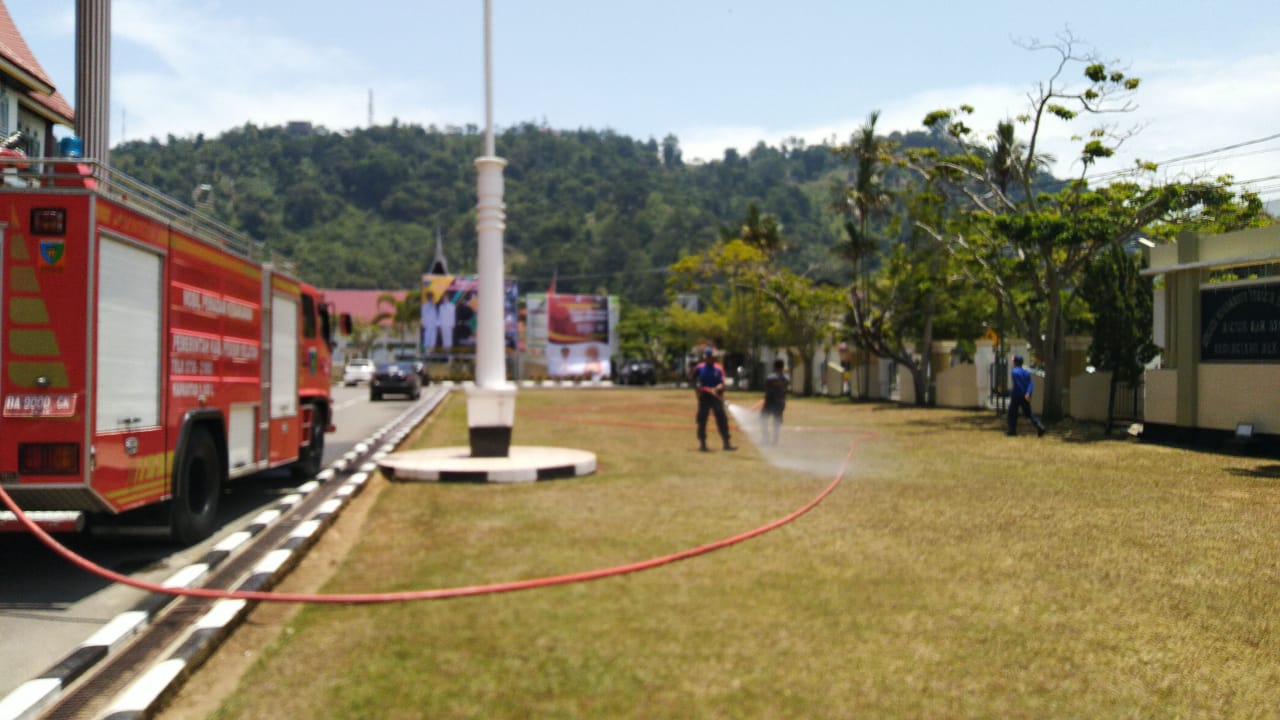 Satpol PP dan Damkar Melakukan Penyemprotan air di depan Kantor Bupati